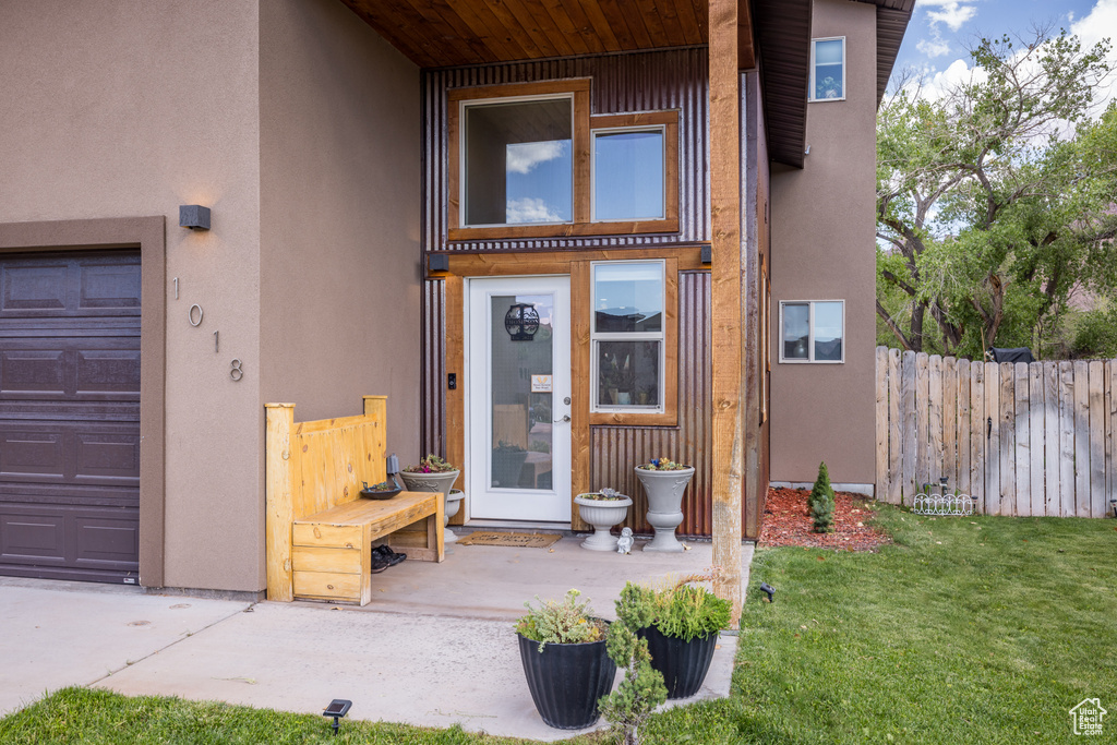 View of exterior entry featuring stucco siding and a garage