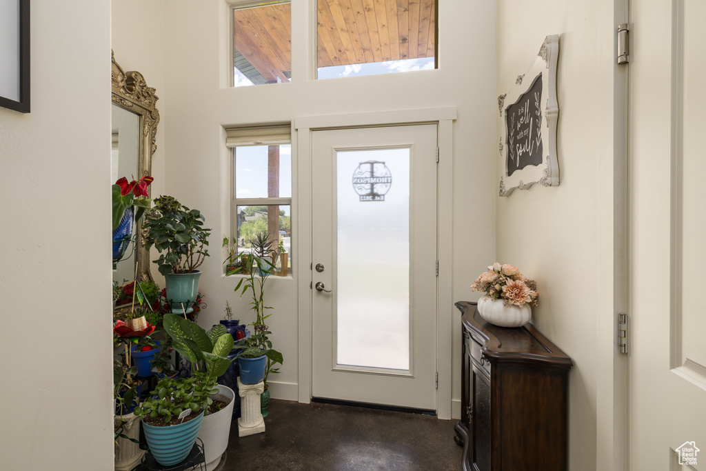 Foyer with finished concrete flooring and a towering ceiling
