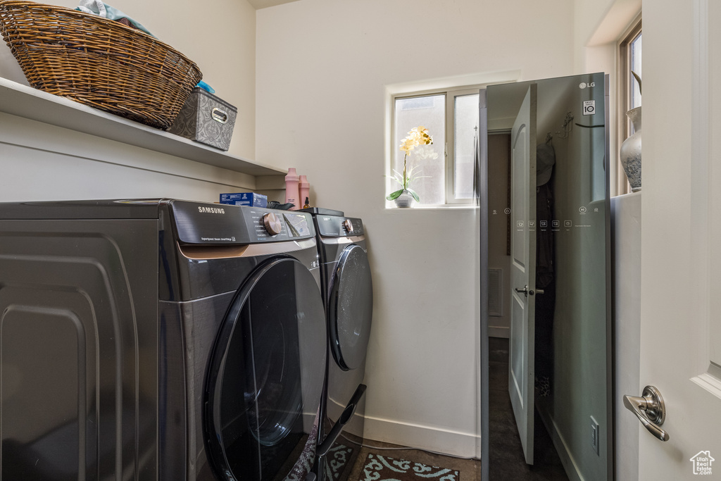 Washroom with separate washer and dryer and baseboards