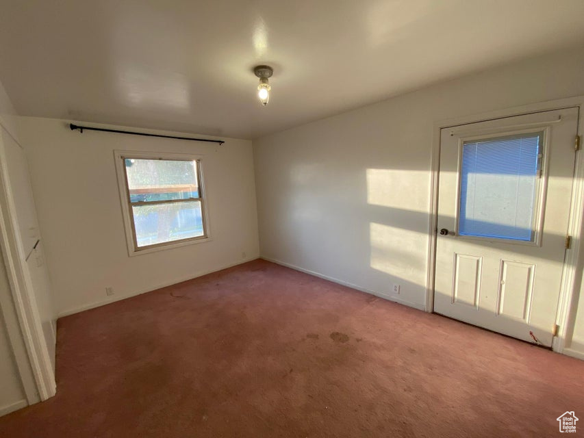 Spare room with light colored carpet and baseboards