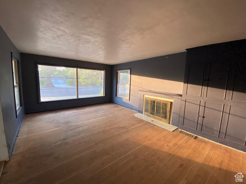 Unfurnished living room featuring hardwood / wood-style flooring and a fireplace