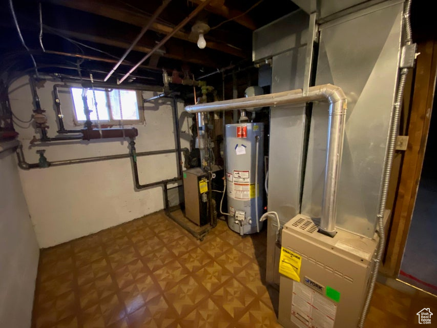 Basement featuring water heater and heating unit