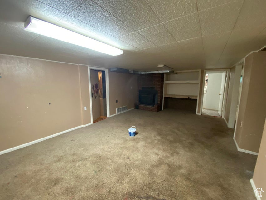 Finished basement with a fireplace and carpet