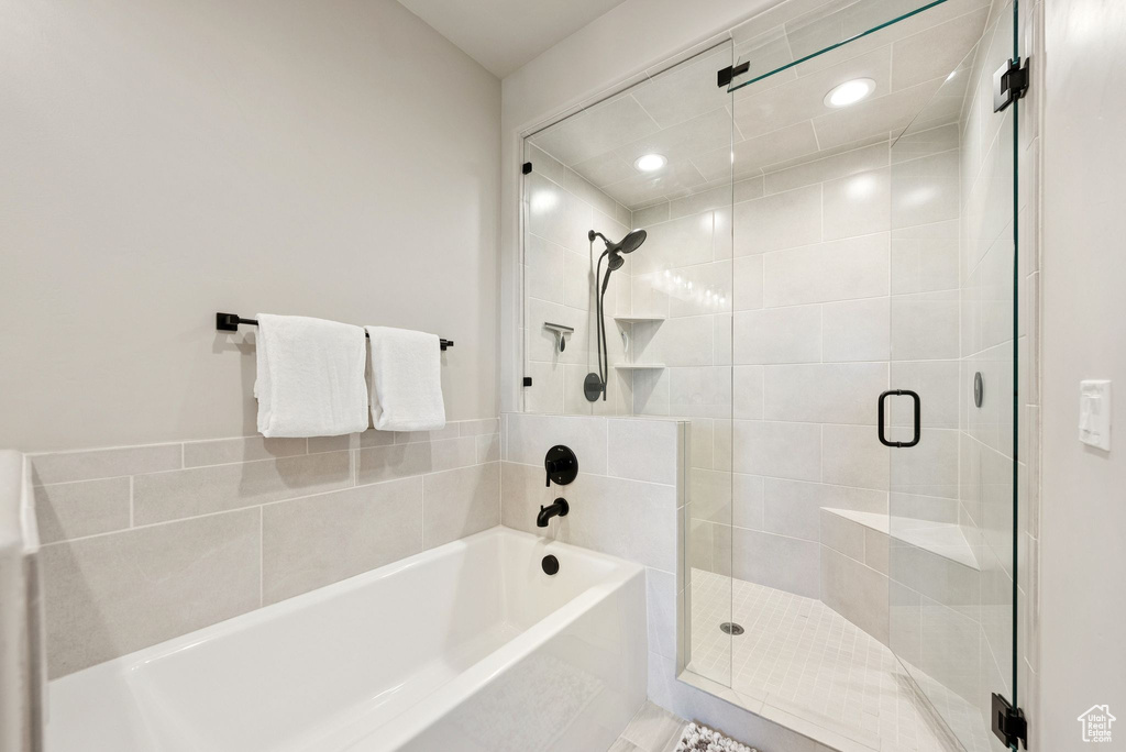 Bathroom featuring a shower stall and a bath