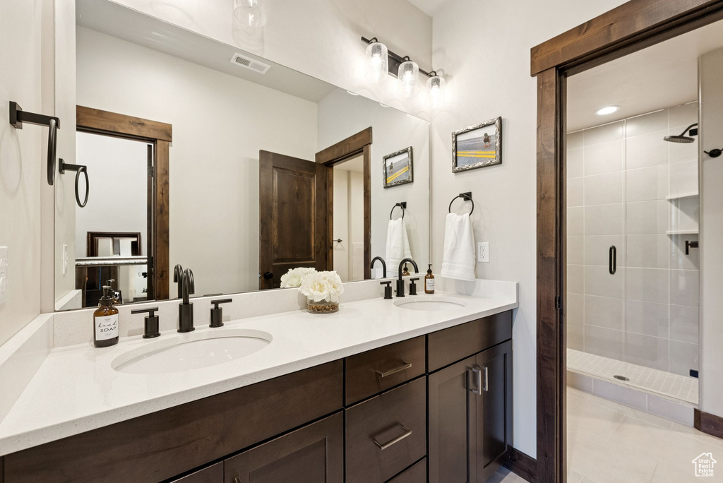 Full bath featuring a stall shower, double vanity, and tile patterned floors