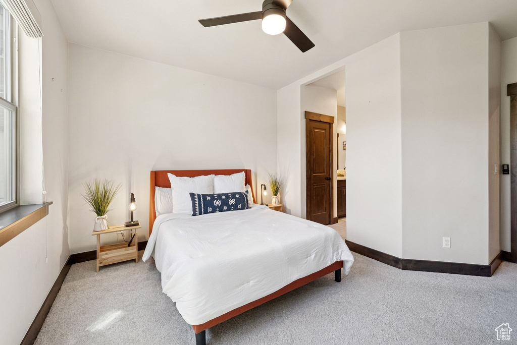 Bedroom featuring carpet floors, a ceiling fan, and ensuite bathroom