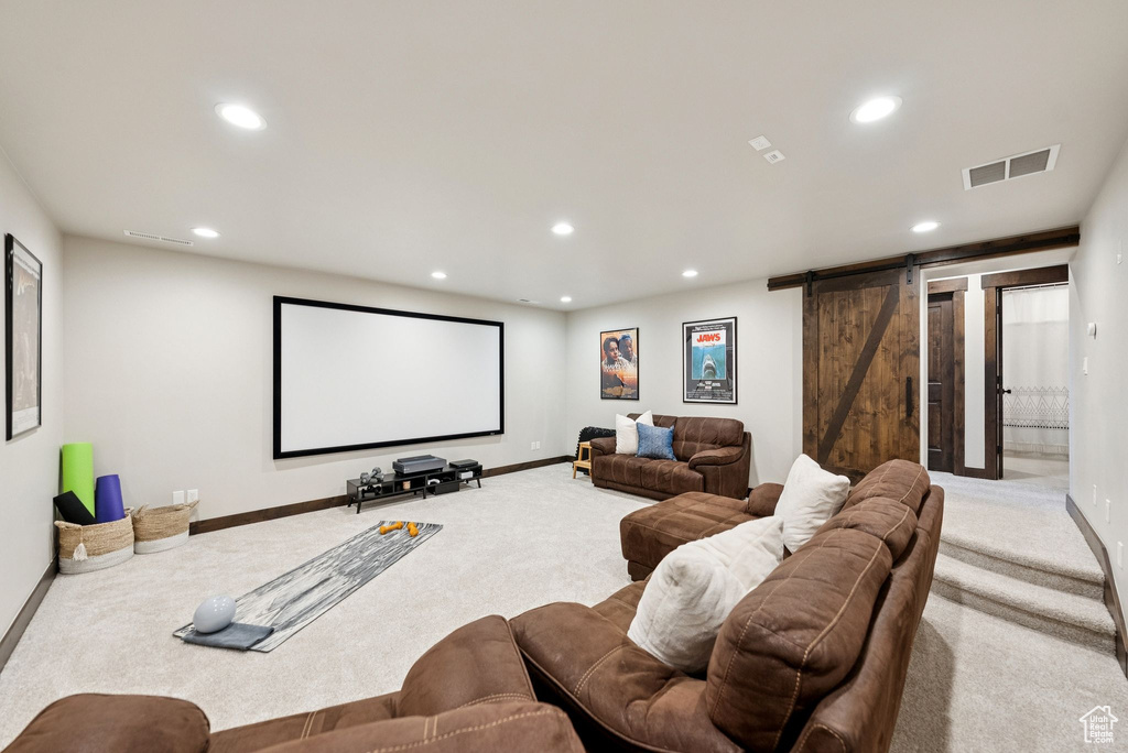 Home theater room with carpet flooring, a barn door, and recessed lighting