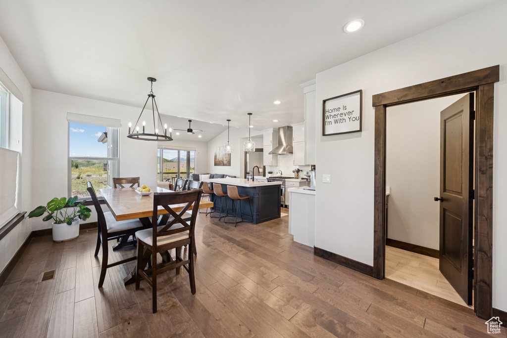 Dining space with hardwood / wood-style floors, a chandelier, and recessed lighting