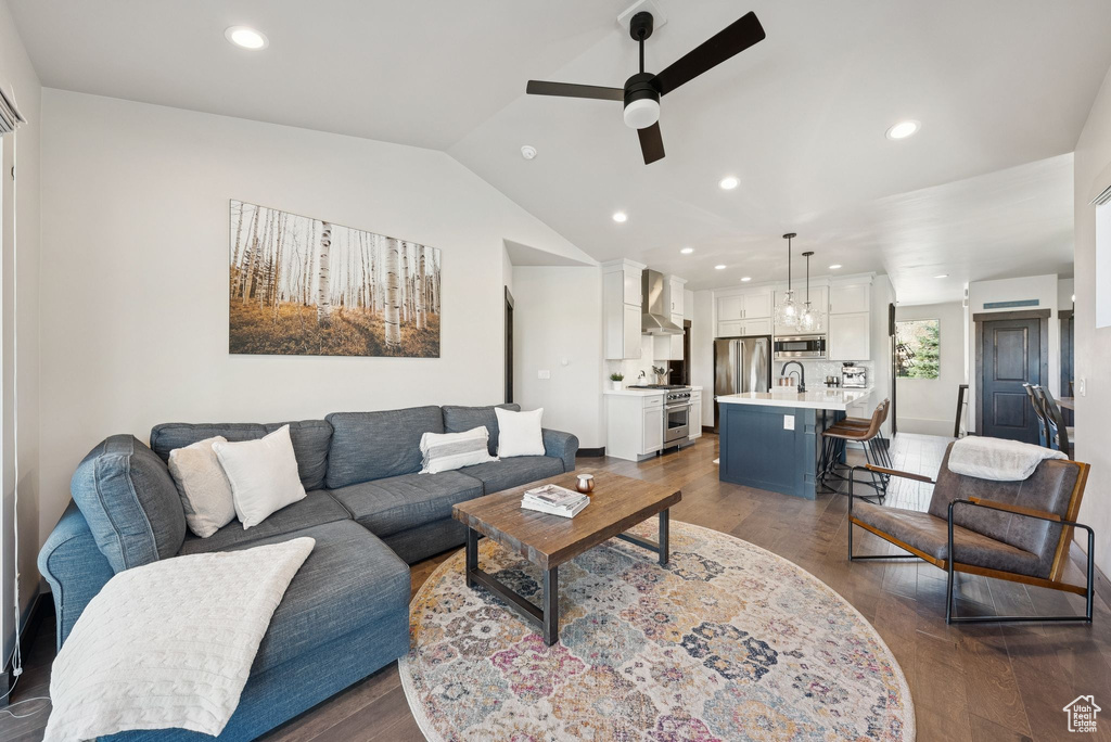 Living room with ceiling fan, vaulted ceiling, dark wood-style floors, and recessed lighting