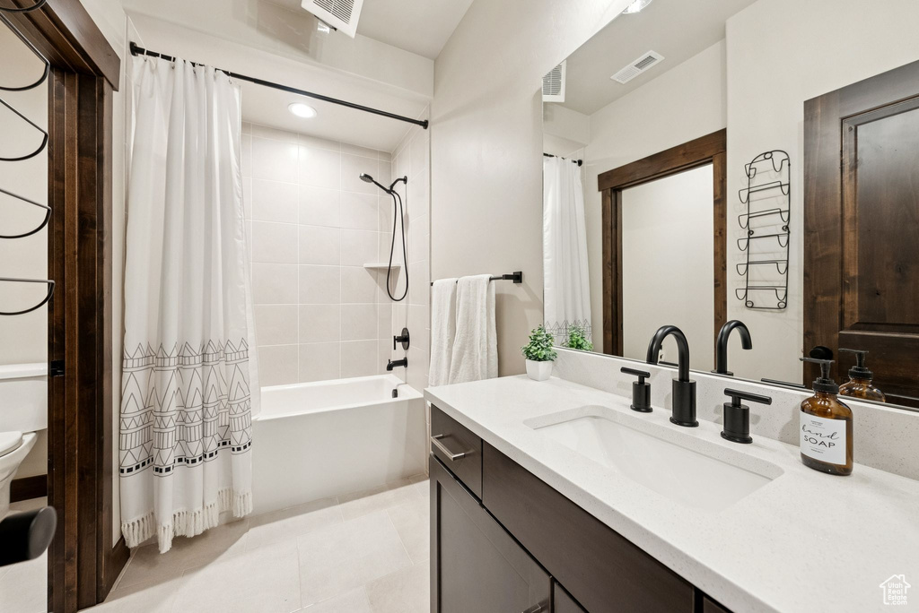 Bathroom featuring vanity, shower / tub combo, tile patterned flooring, and recessed lighting