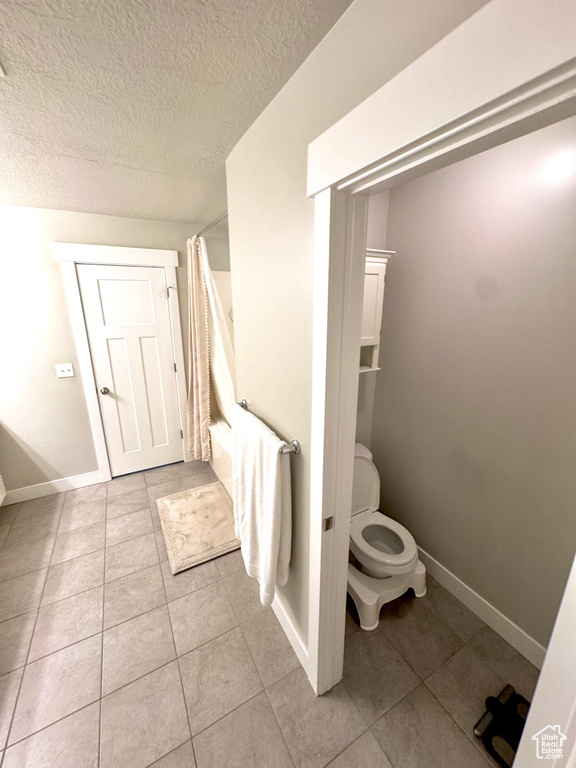 Full bath featuring tile patterned flooring and a textured ceiling