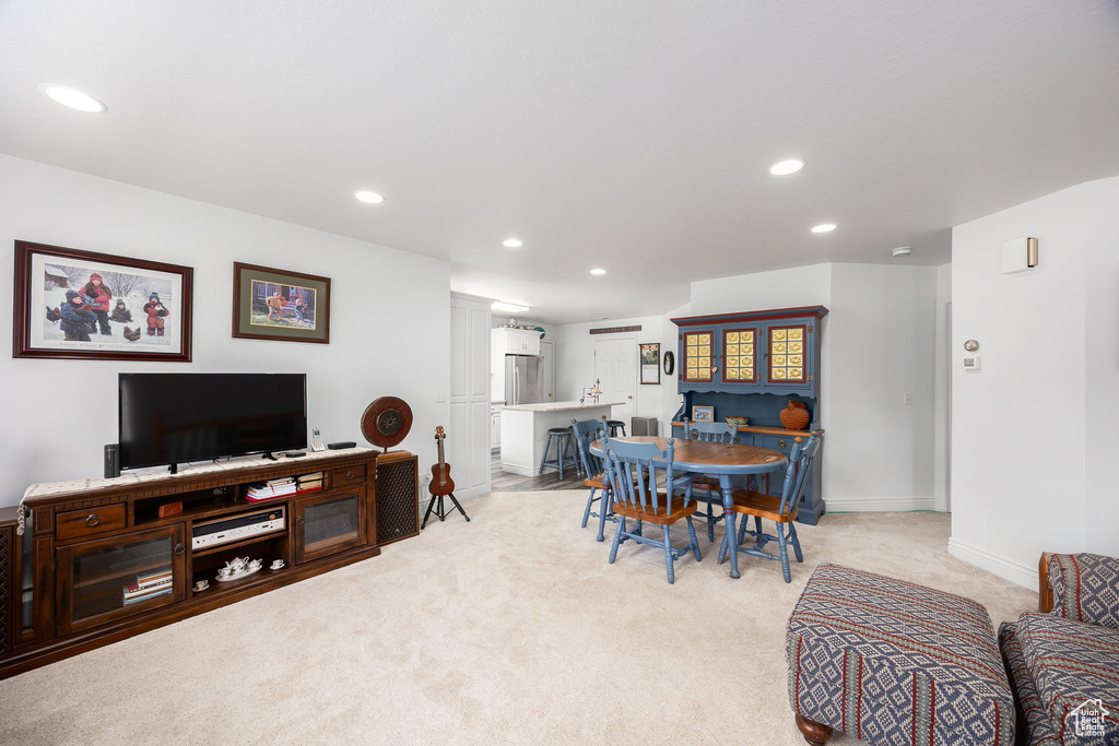 Dining space with light carpet and recessed lighting