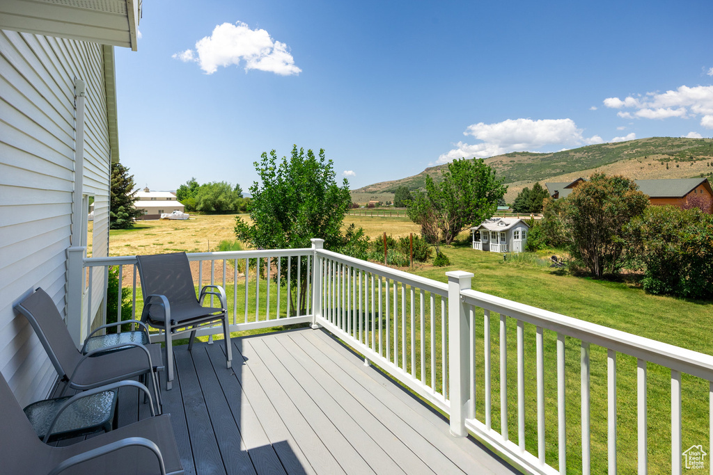 Deck featuring a mountain view and a lawn