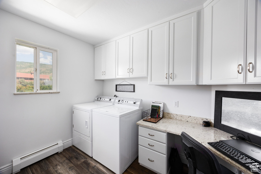 Laundry area featuring a baseboard radiator, washing machine and dryer, dark wood-style floors, cabinet space, and an office area