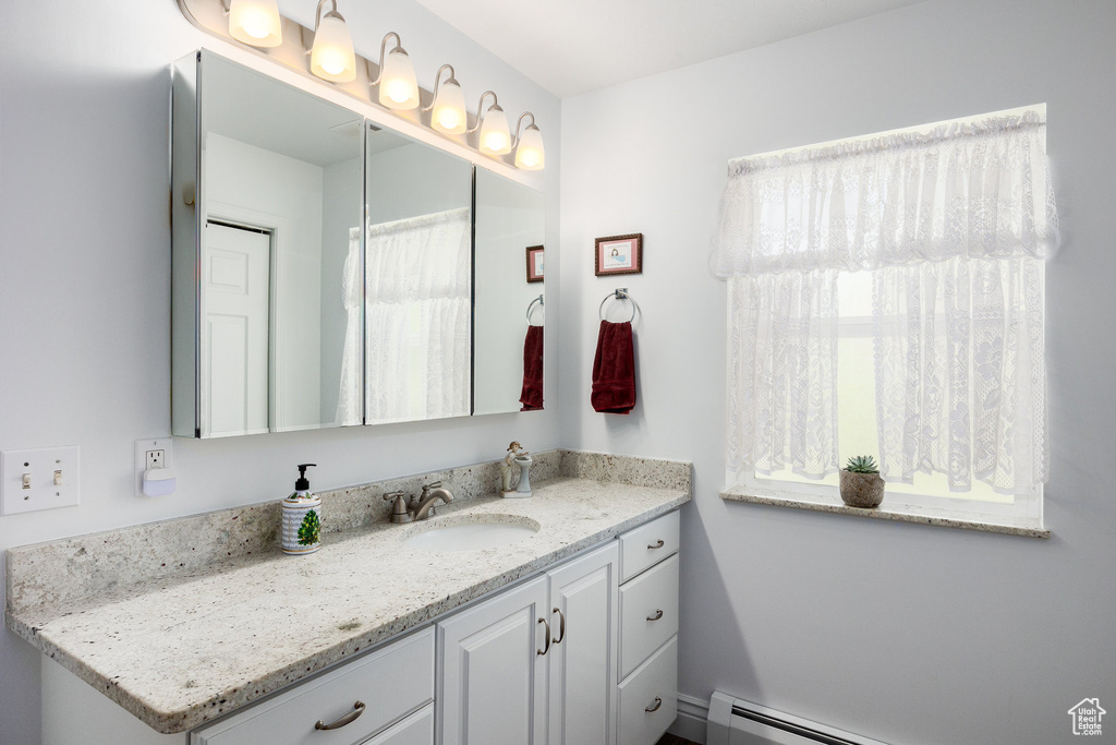 Full bath with vanity and baseboard heating