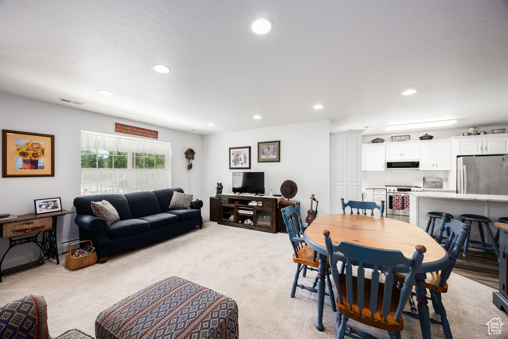 Dining area with baseboard heating, light colored carpet, and recessed lighting