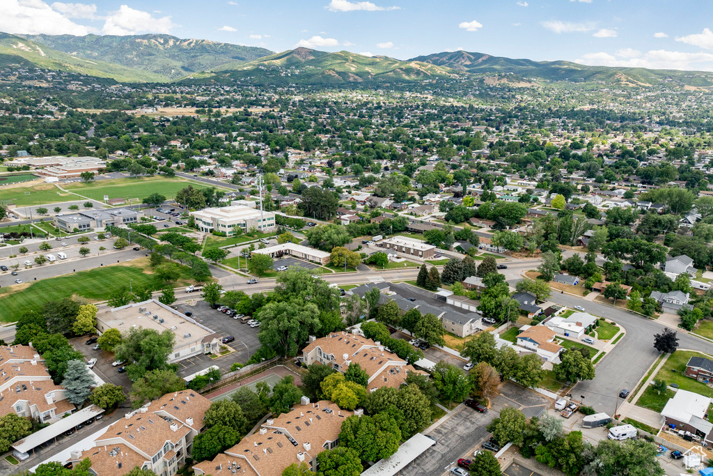 Aerial view of property and surrounding area featuring a mountainous background