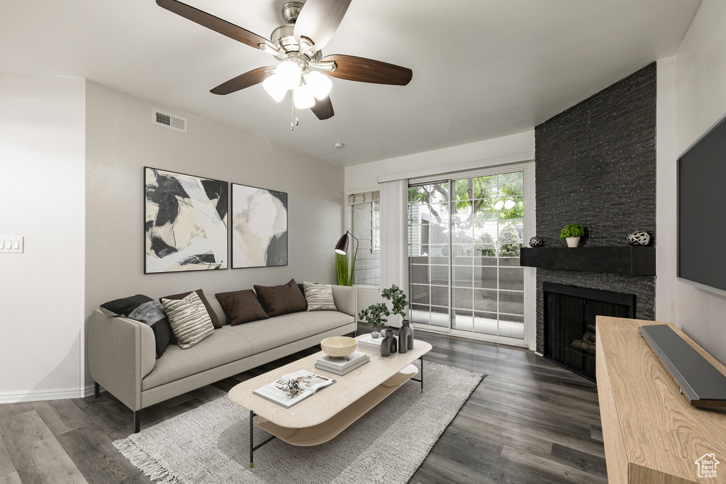 Living area featuring a ceiling fan, dark wood-style floors, and a fireplace