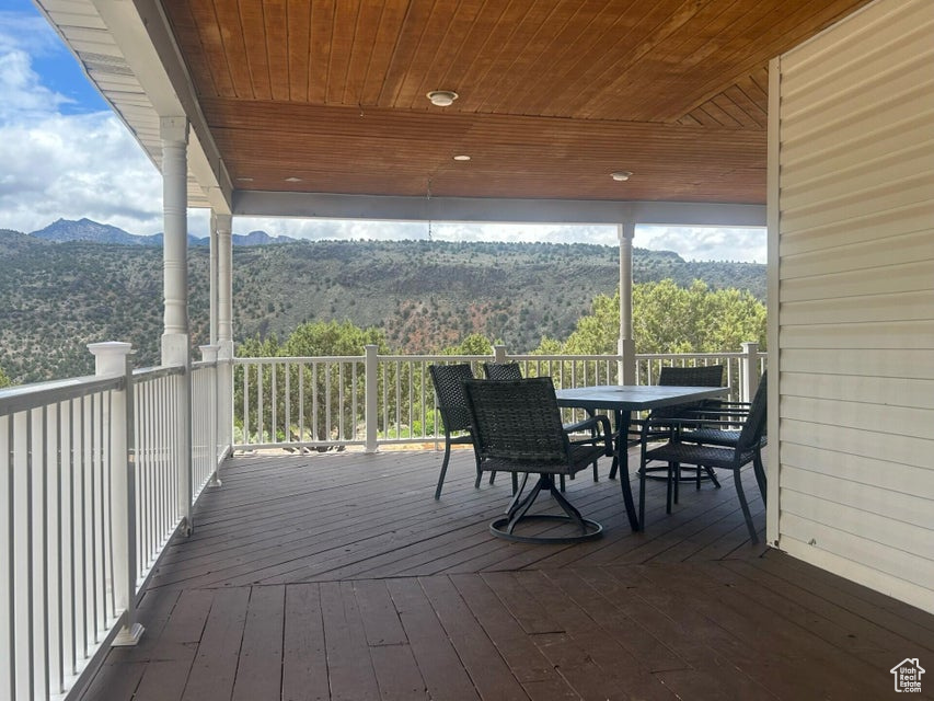 Wooden terrace featuring outdoor dining space and a mountain view