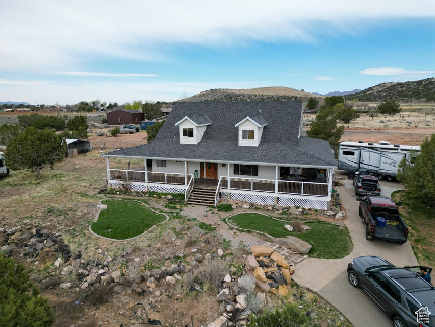 Farmhouse-style home with a porch, roof with shingles, and a mountain view