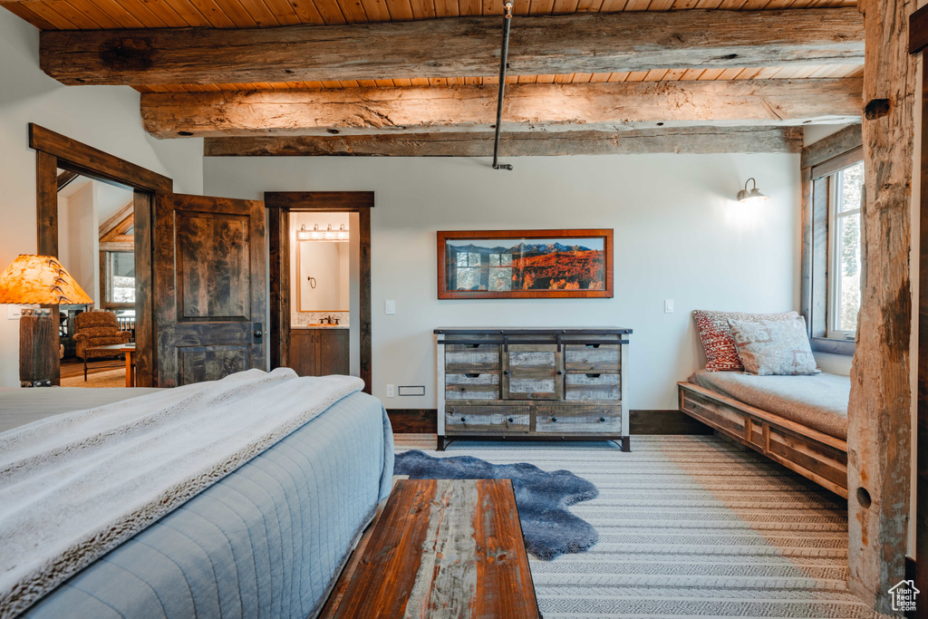 Bedroom featuring a wooden ceiling with exposed beams and connected bathroom