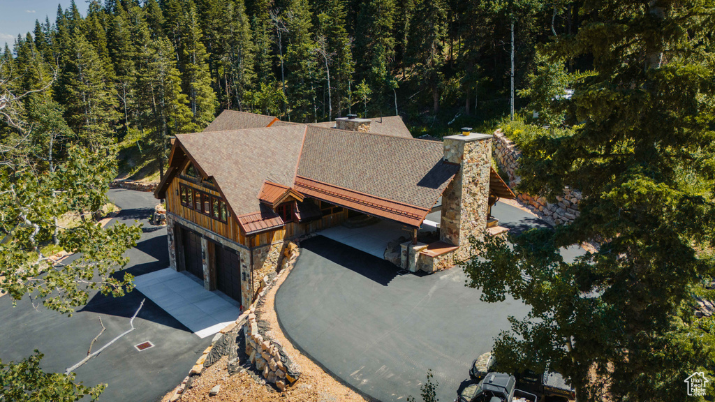 Aerial view of property and surrounding area with a heavily wooded area