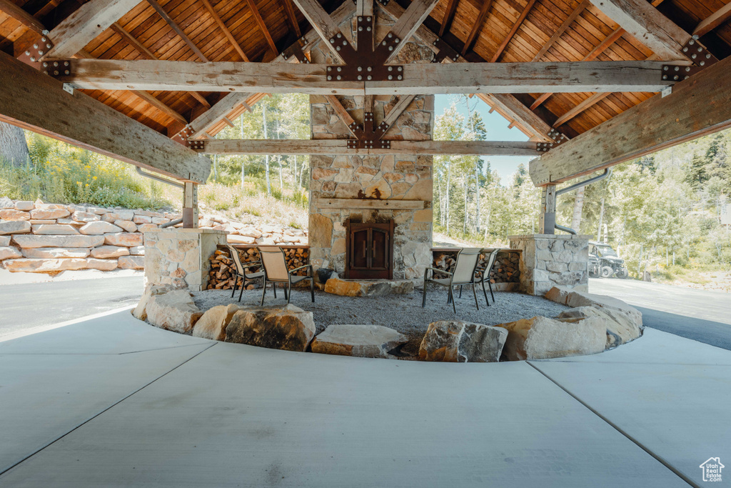 View of patio featuring an outdoor stone fireplace and a gazebo