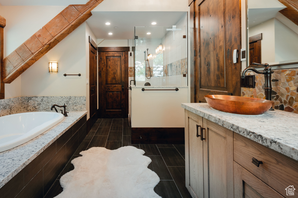 Bathroom with a shower stall, a garden tub, vanity, recessed lighting, and backsplash
