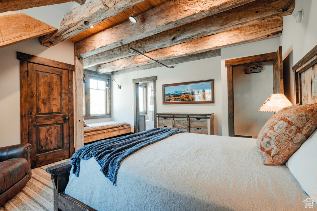 Bedroom with beam ceiling and wood finished floors