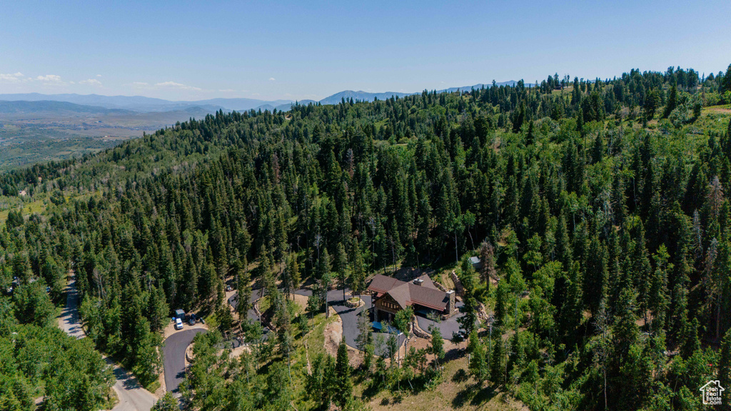 View of property location with a forest and a mountainous background