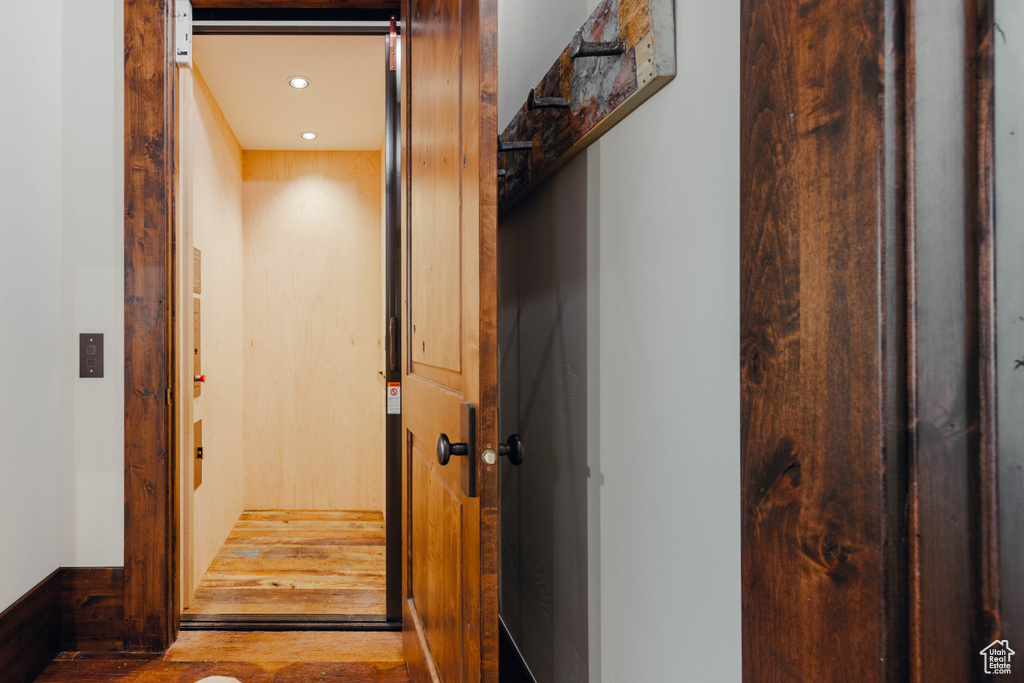 Hall featuring elevator, wood finished floors, and recessed lighting
