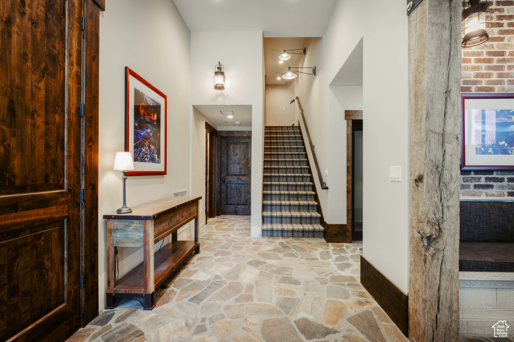 Foyer entrance featuring stone flooring and stairway