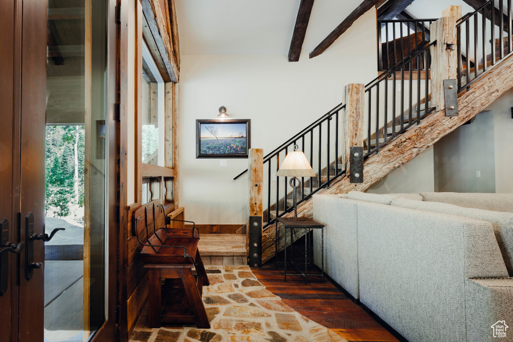 Foyer featuring wood-type flooring, stairway, and beamed ceiling