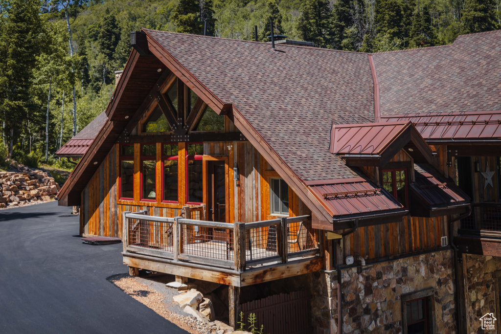Back of house featuring a standing seam roof, roof with shingles, and a metal roof