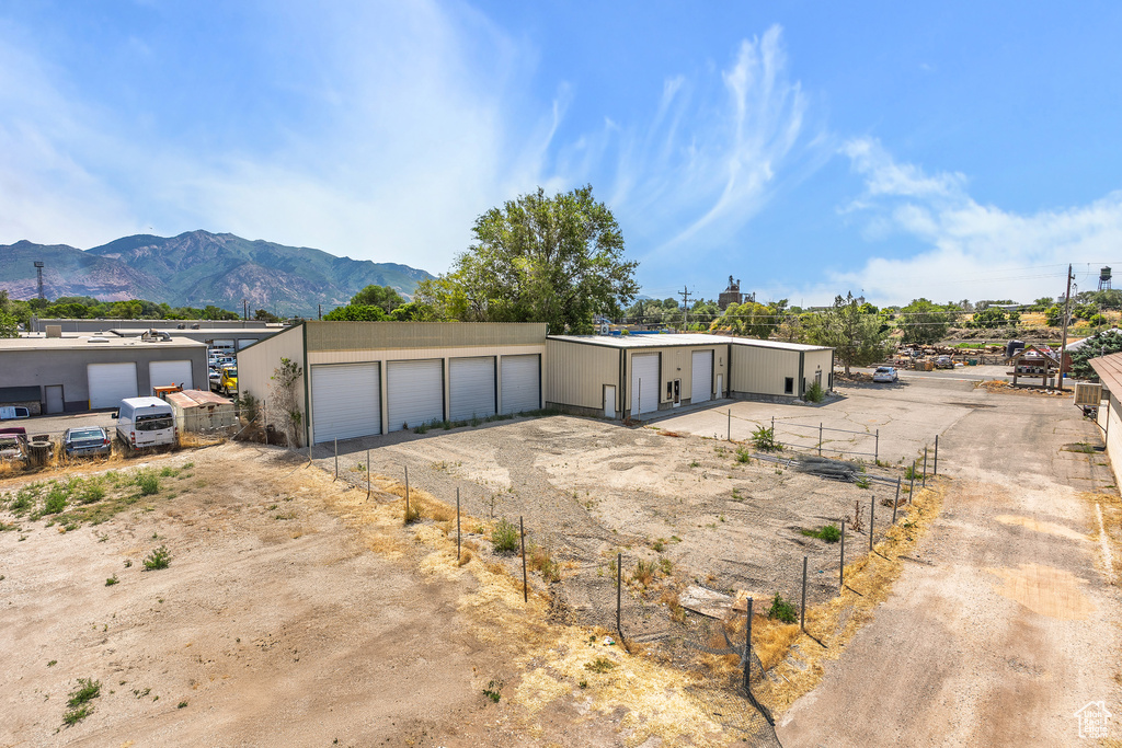 View of front of house featuring a detached garage, a mountain view, an outbuilding, and driveway