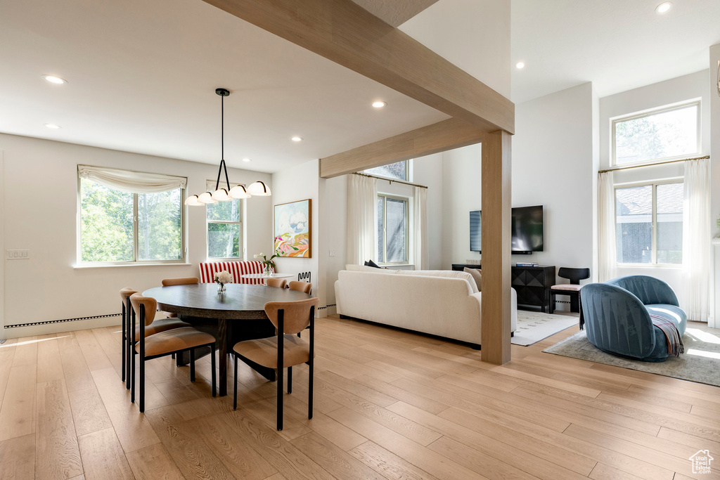 Dining room with light wood finished floors, recessed lighting, a chandelier, and a baseboard heating unit