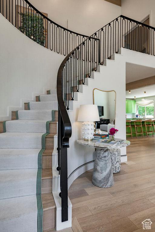 Stairway with a high ceiling and wood finished floors