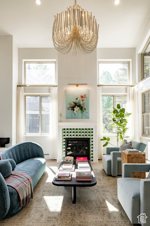 Living room featuring healthy amount of natural light, a chandelier, recessed lighting, and a tiled fireplace