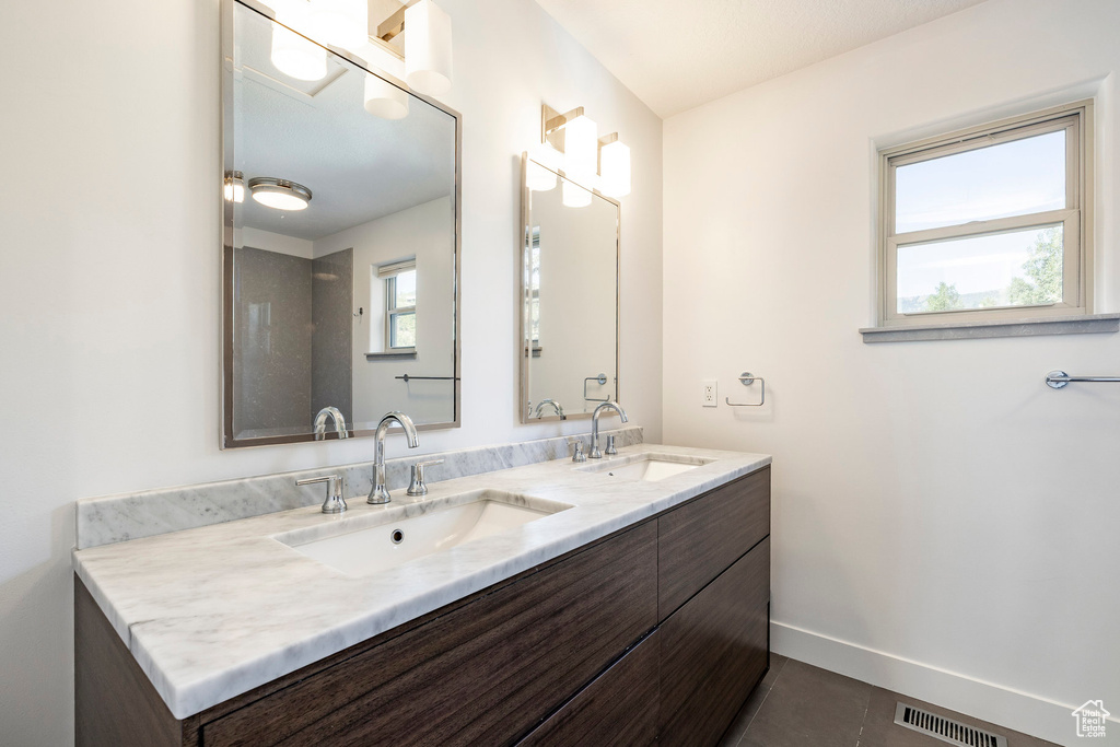 Full bathroom featuring double vanity and tile patterned flooring