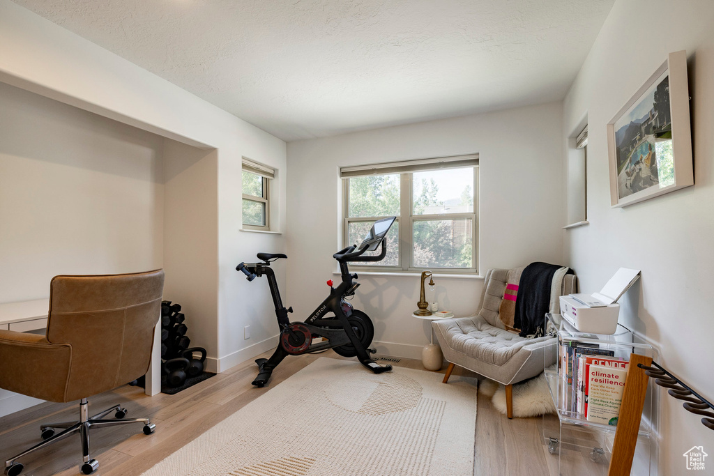 Exercise room featuring wood finished floors and baseboards