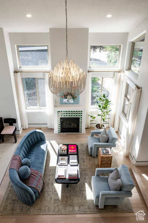 Living area with plenty of natural light, a baseboard radiator, a chandelier, recessed lighting, and wood finished floors
