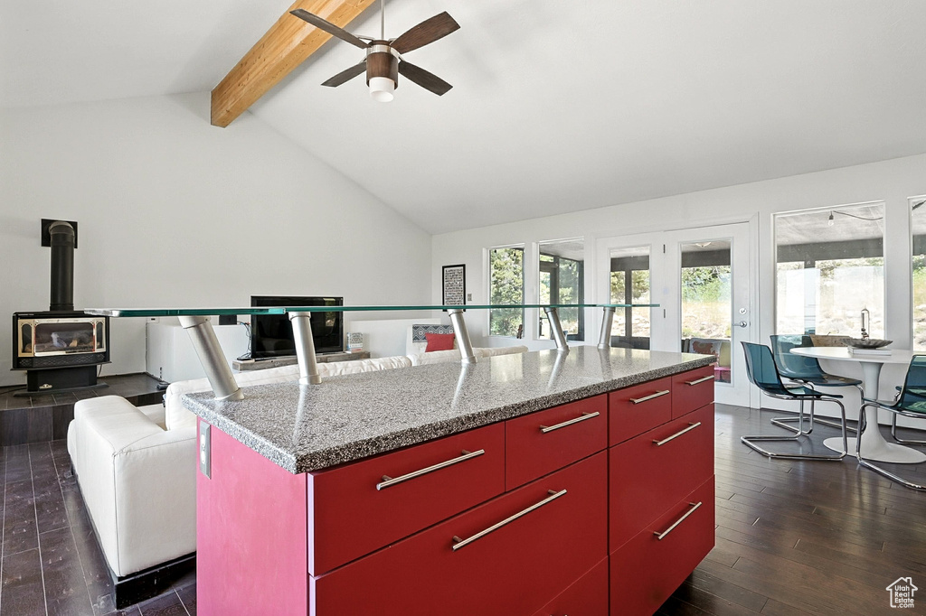 Kitchen with red cabinets, ceiling fan, dark wood-style flooring, a wood stove, and yellow cabinetry