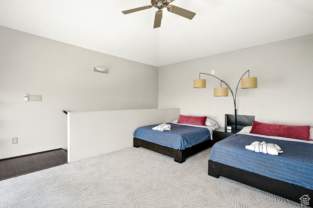 Bedroom featuring a ceiling fan, vaulted ceiling, and wood finished floors
