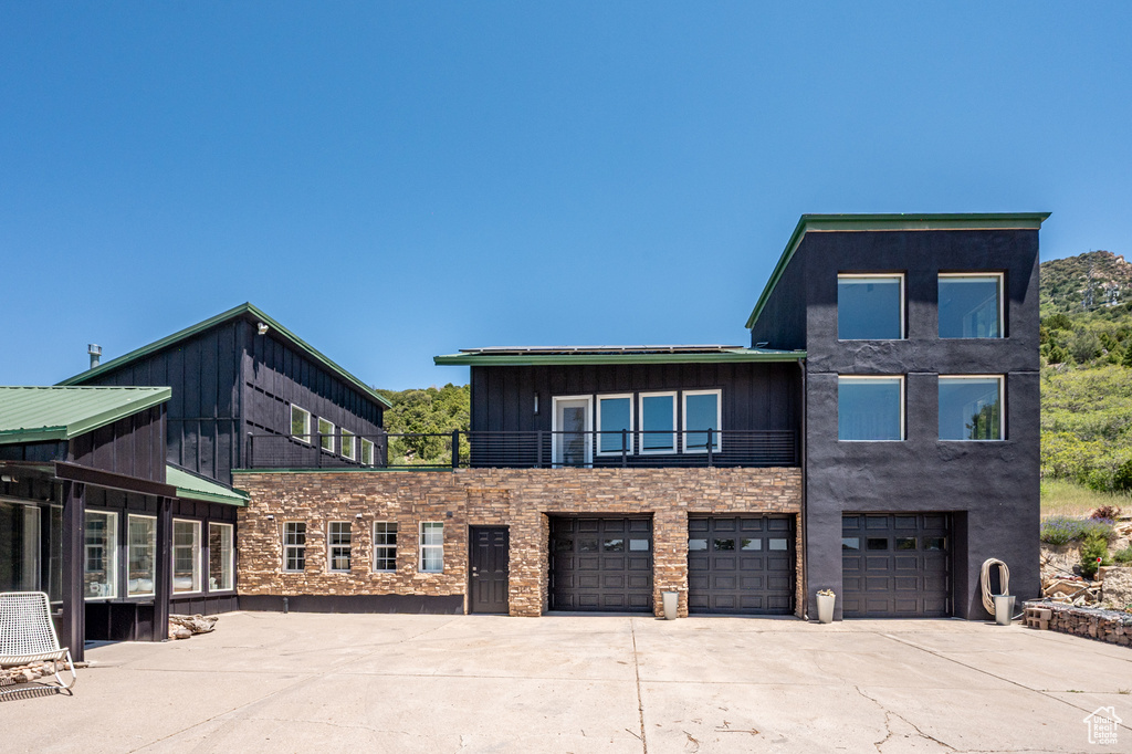 View of building exterior with concrete driveway and a garage