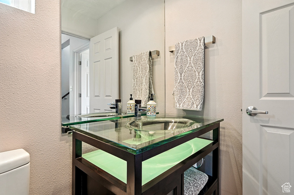 Bathroom featuring a textured wall and vanity