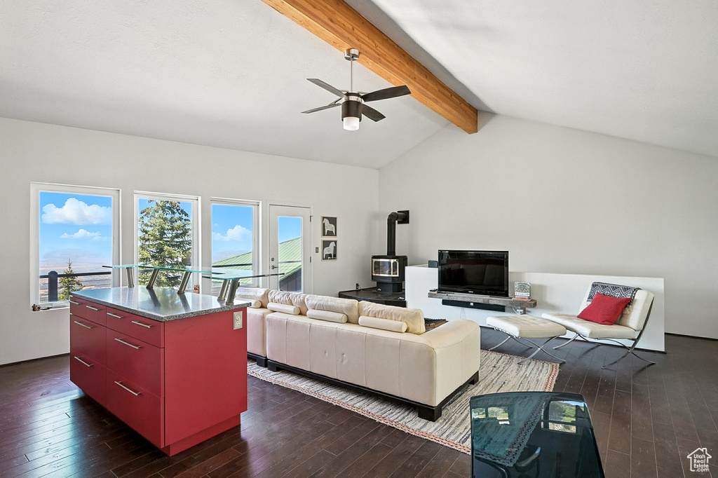 Living room with a wood stove, dark wood-style flooring, and a ceiling fan