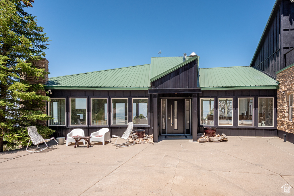 Rear view of house featuring a patio area, a metal roof, and board and batten siding