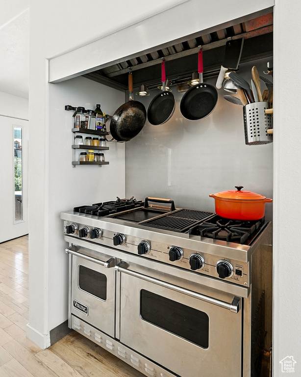 Kitchen with double oven range and light wood-style floors