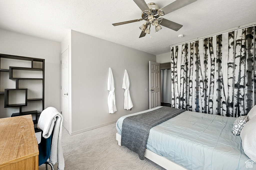 Carpeted bedroom with baseboards and ceiling fan