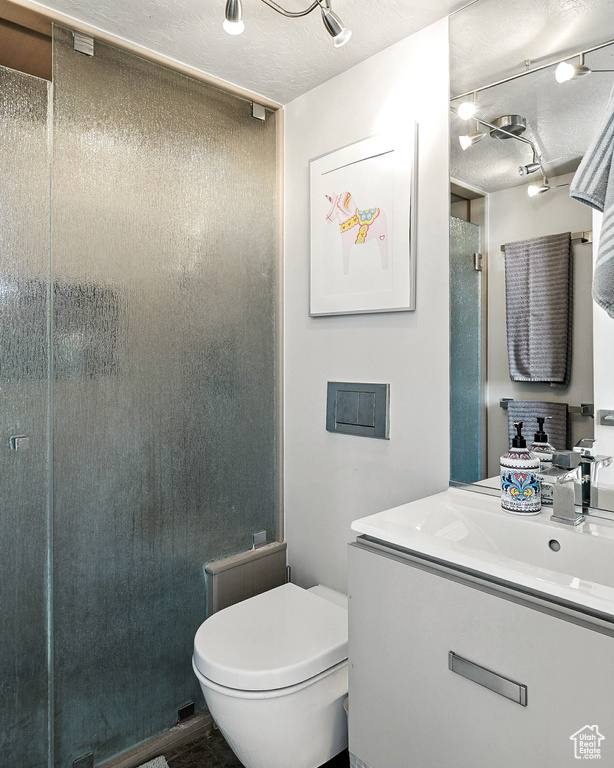 Bathroom featuring vanity, a stall shower, and a textured ceiling
